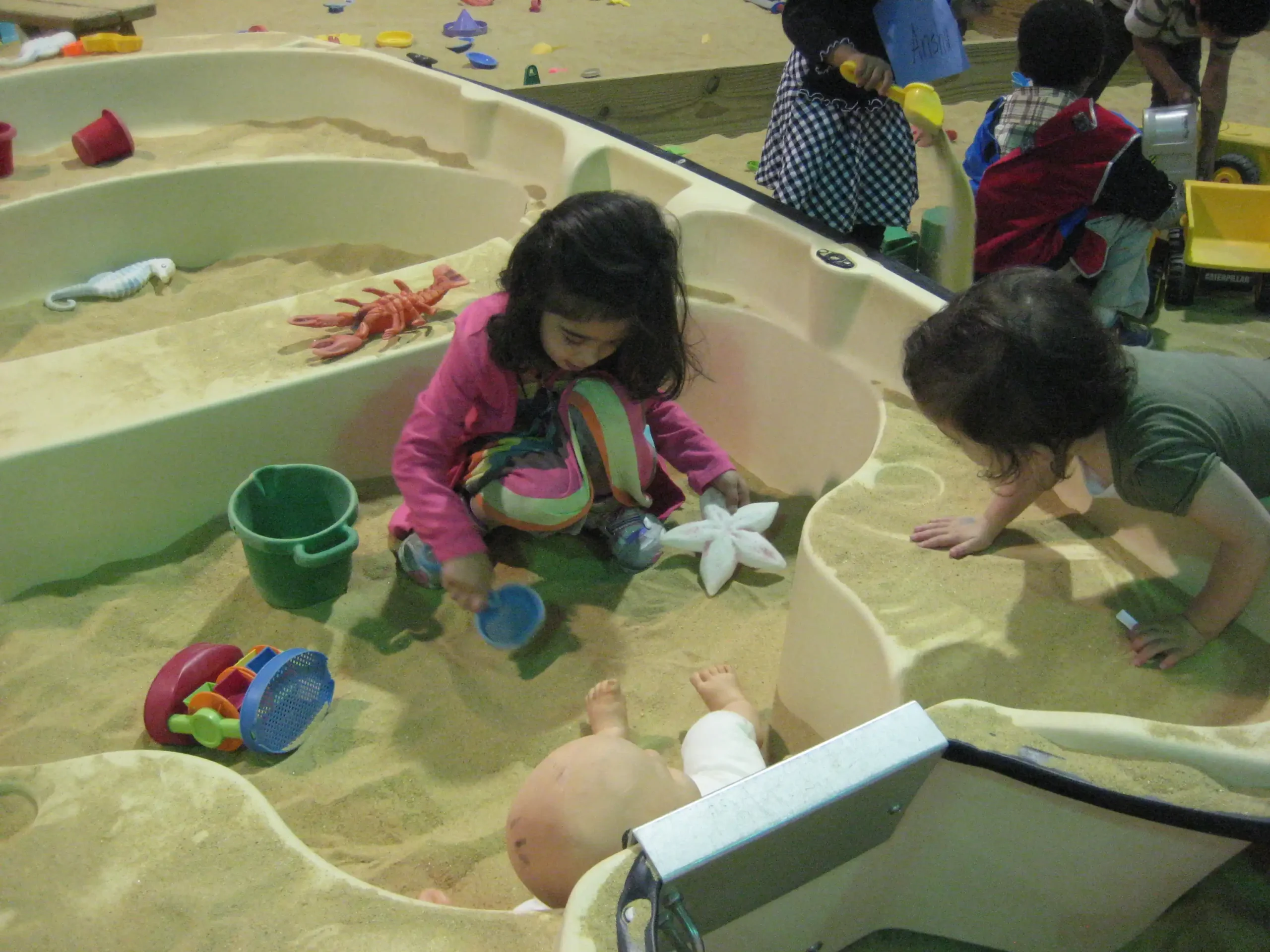 Group of girls climbing on a climbing wall in kid's playroom